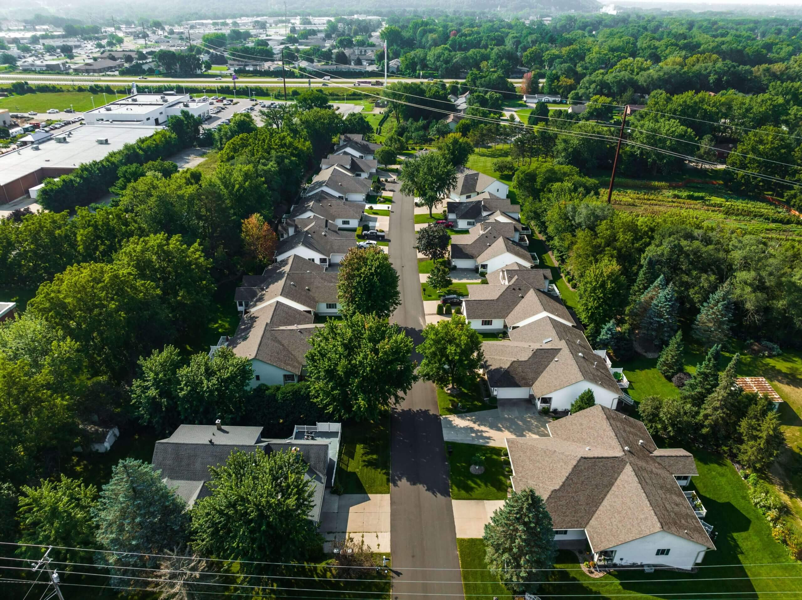Aerial view of suburban residential neighborhood with houses surrounded by trees