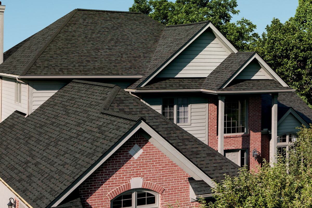 Modern brick house with dark asphalt shingle roof and multiple gables