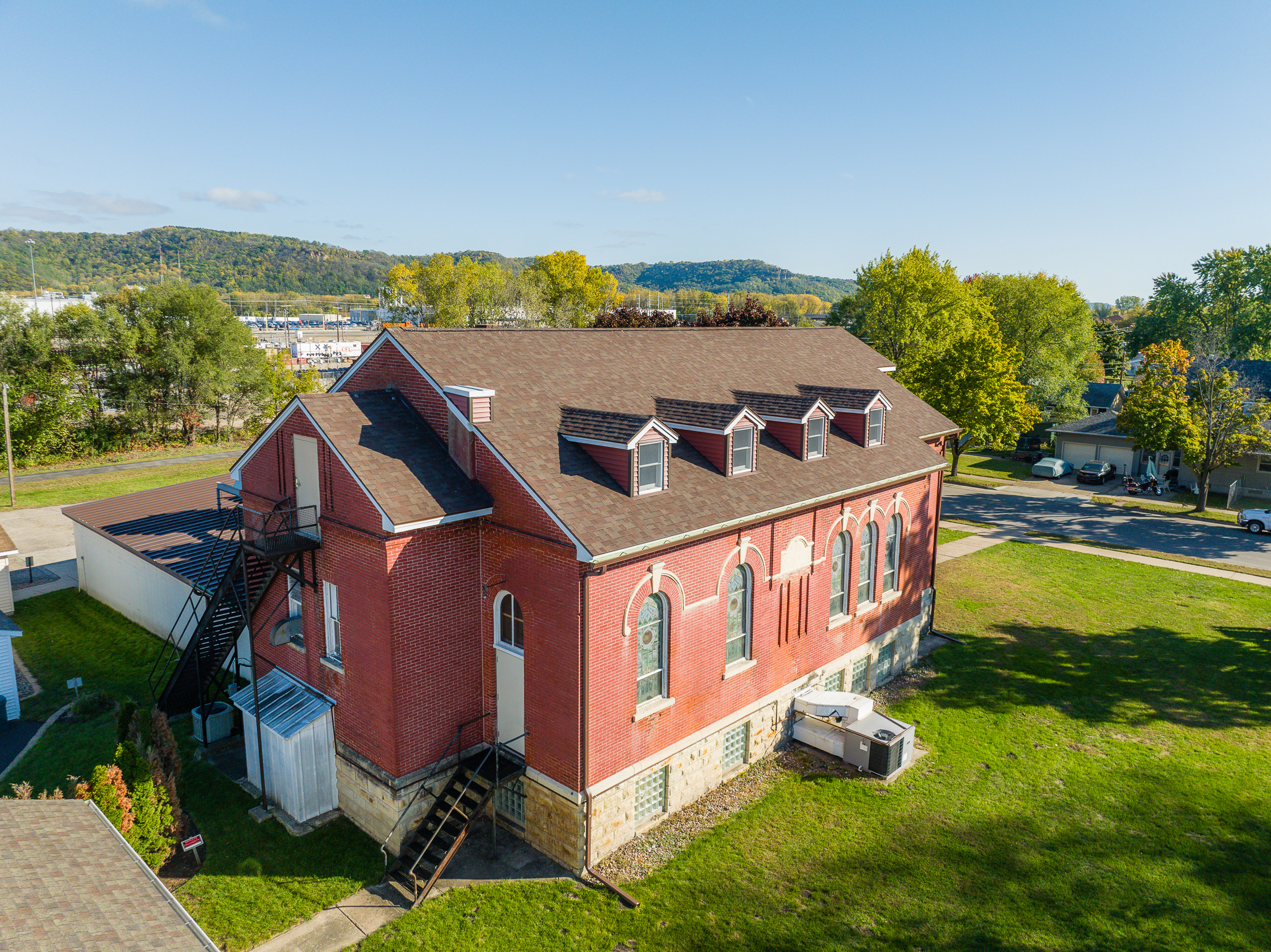 Aerial view of a historic red brick building with arched windows and rooftop details.