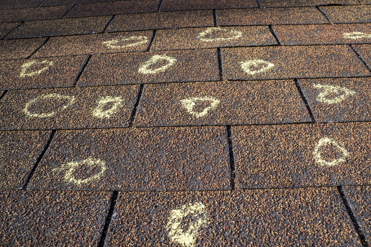 Roof shingles with chalk circles indicating hail damage.